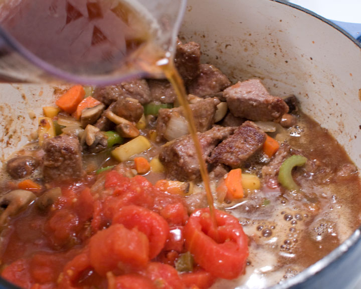 pouring stock into the stew