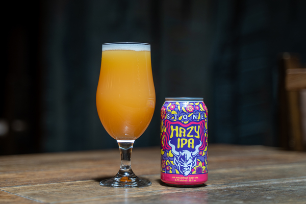 glass and can of Stone Hazy IPA