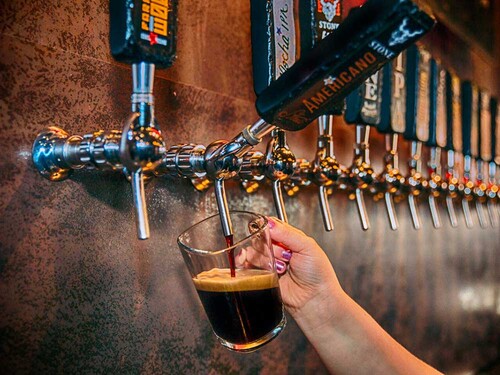 bartender filling a glass with Stone Americano Stout