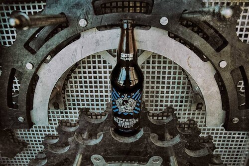 Stone Imperial Russian Stout bottle in front of cool mechanical contraption