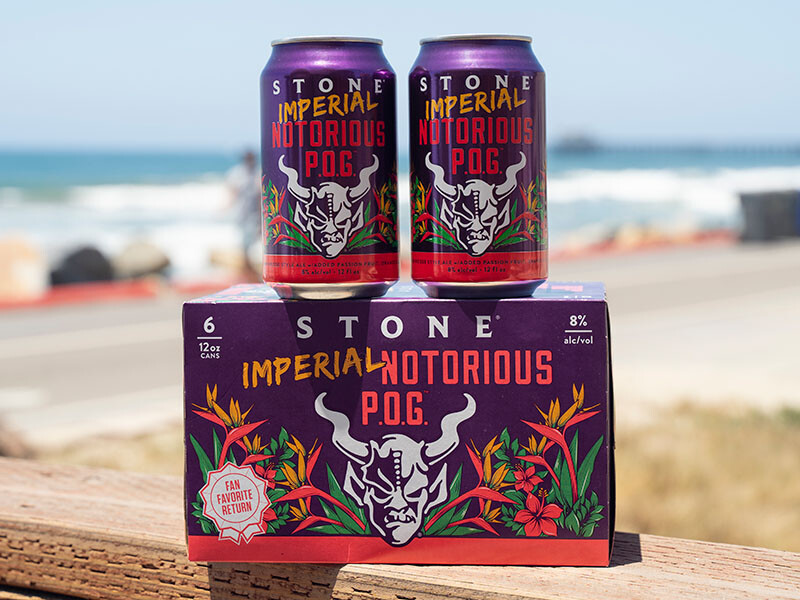cans and a six-pack Stone Imperial Notorious P.O.G. beer on the beach of the pacific ocean