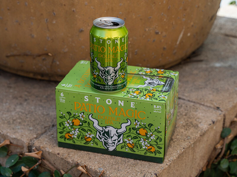 Stone Patio Magic Double IPA can and six-pack by a planter