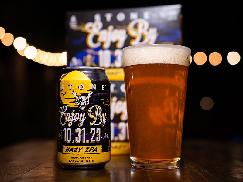 can, glass and six-pack of Stone Enjoy By 10.31.23 Hazy IPA beer