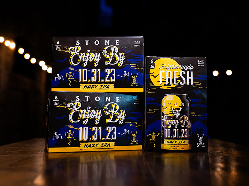 three six-packs of the Stone Enjoy By 10.31.23 Hazy IPA at night