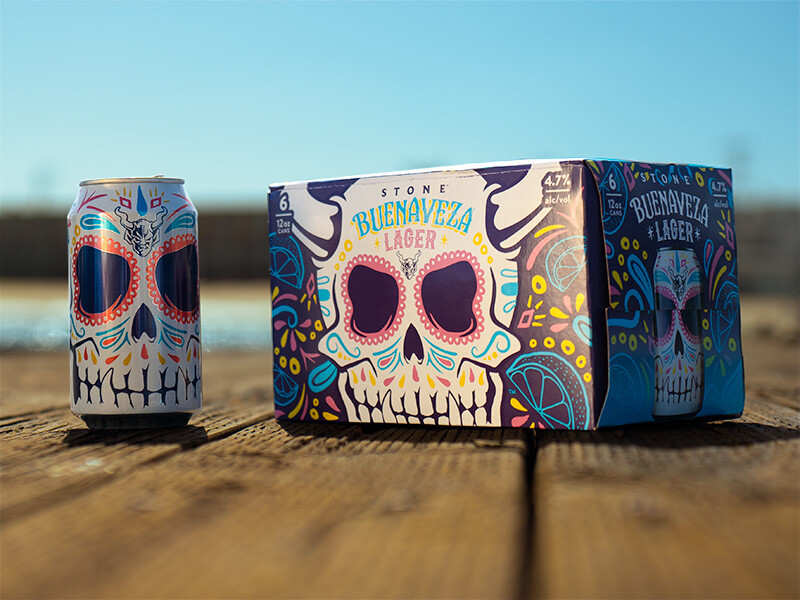 a can and a six-pack of Stone Buenaveza Lager on the dock