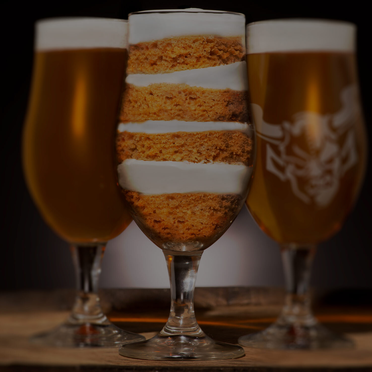 glass of carrot cake flanked by glasses of Juli Goldenberg / Monkey Paw / Stone 24 Carrot Golden Ale