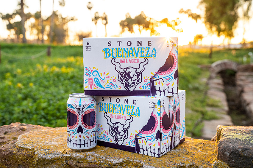 Can and six packs of buenaveza in front of the sunset