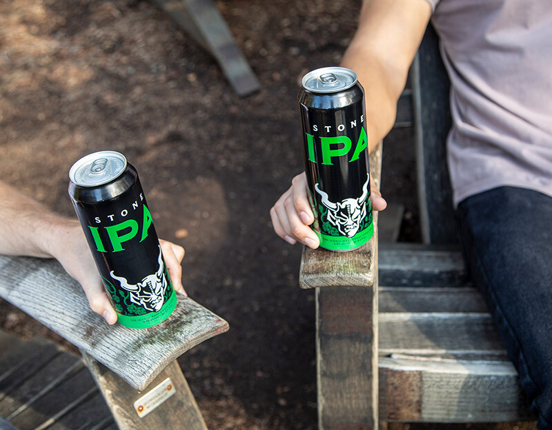 Holding stone IPA cans in chairs