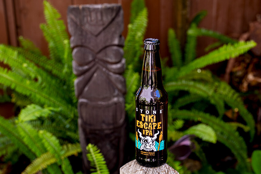 Stone Tiki Escape IPA bottle in front of a tiki idol