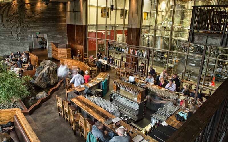 a shot of the bistro and the large glass windows leading to the main stone brewing brewery in the esocndido restaurant